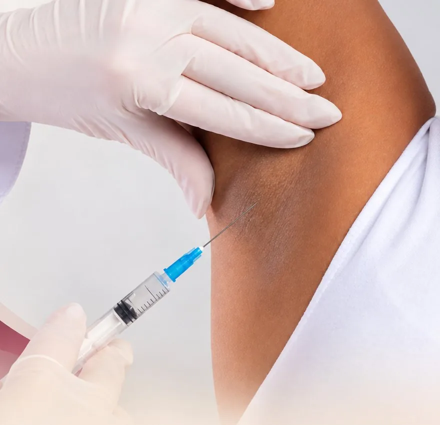 Médico aplicando un tratamiento en la axila de una paciente