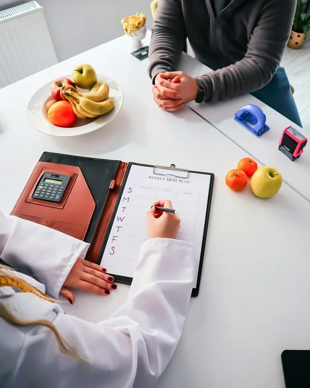 Nutricionista preparando un plan de alimentación con un paciente